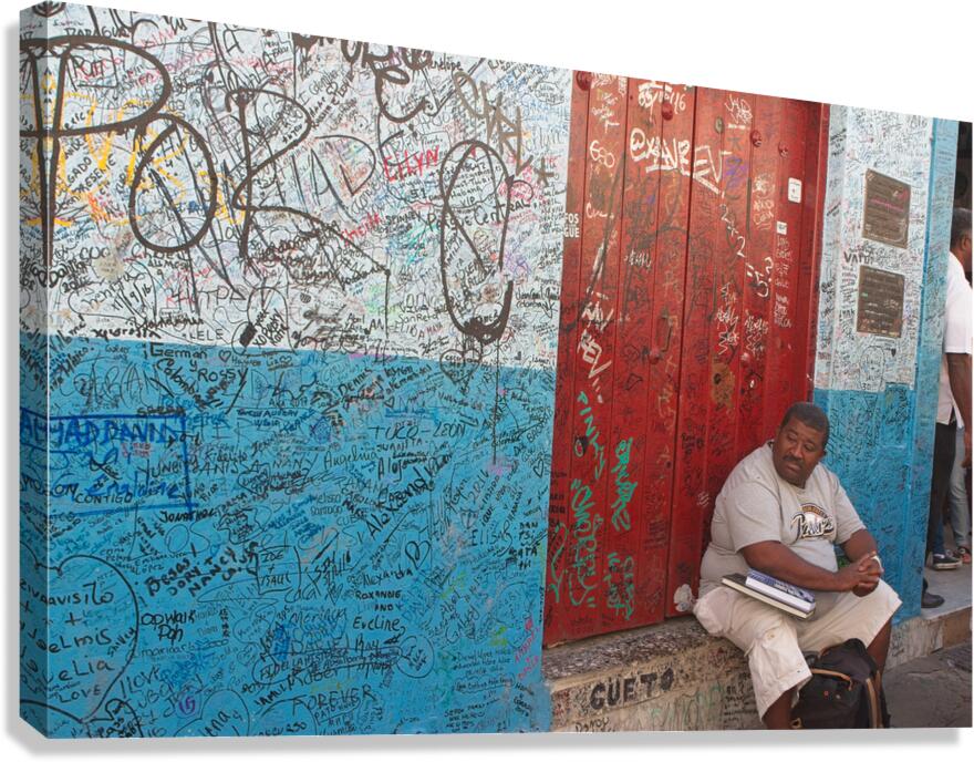Graffiti-Covered Wall with Seated Man Canvas Print